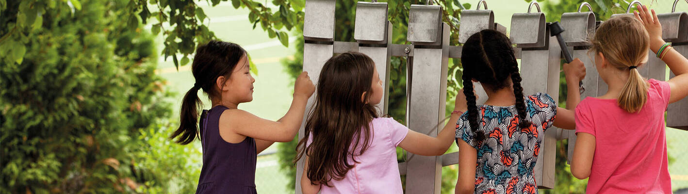 Four girls playing together on a sound wall