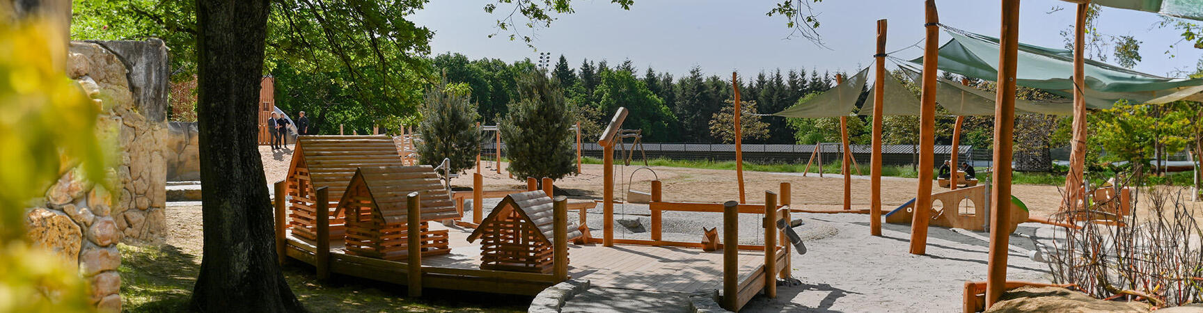 Der Waldspielplatz hat nicht nur tolle Rutschen, Schaukeln, Sandkästen, Holzparcours, Seilbahnen, Kletterwände und Wasserspiele, sondern liegt auch in einer wunderschönen Grünanlage mit hohen Bäumen  und atemberaubender Natur