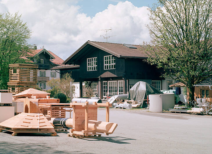 Werkstatt von Innen, in der ein Mitarbeiter gerade Holz schneidet